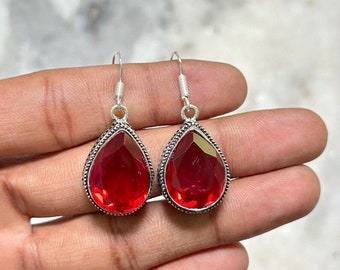 Peut inclure: Une paire de boucles d'oreilles pendantes en argent avec des pierres précieuses rouges en forme de goutte.