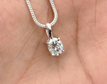 May include: A silver chain necklace with a round, clear, sparkling pendant.