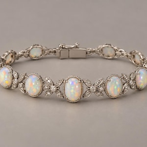 May include: A silver-toned bracelet featuring a series of oval-shaped iridescent opals set in metal frames. The opals are connected by decorative metal links adorned with small, clear, round stones. The bracelet includes a secure metal box clasp.