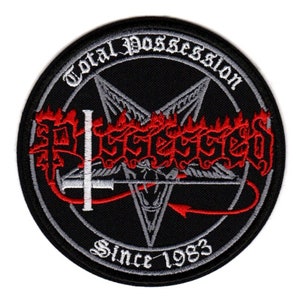 Puede incluir: Parche bordado en blanco y negro con un pentagrama, llamas y el texto "Total Possession" y "Possessed" en fuente gótica. También se incluye el texto "Since 1983".