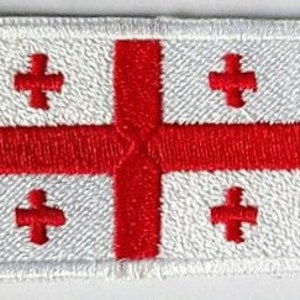 May include: A white rectangular flag with a red cross in the center. The cross is made up of four smaller crosses, each with a white center.