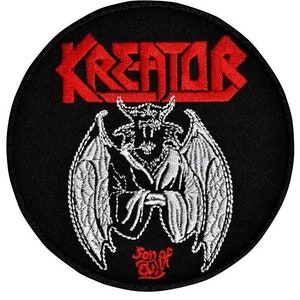 Peut inclure: Un écusson brodé noir et blanc avec le nom du groupe "Kreator" en lettres rouges et un démon ailé blanc avec les mots "Soul of Evil" en lettres rouges en dessous.