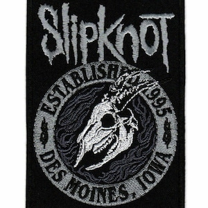 Può includere: Toppa ricamata in bianco e nero con il nome della band "Slipknot" in un font stilizzato. La toppa presenta anche uno scheletro con corna e il testo "Stabilito 1995 Des Moines, Iowa".