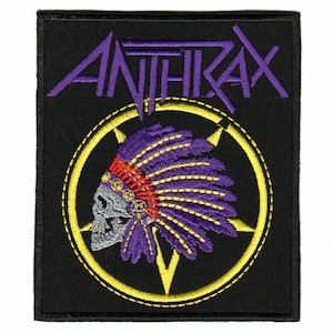 Könnte beinhalten: Gestickter Aufnäher mit dem Wort "ANTHRAX" in Lila über einem Totenkopf mit indianischer Kopfbedeckung. Der Totenkopf und die Kopfbedeckung befinden sich in einem gelben Kreis mit Sternmuster auf schwarzem Hintergrund.