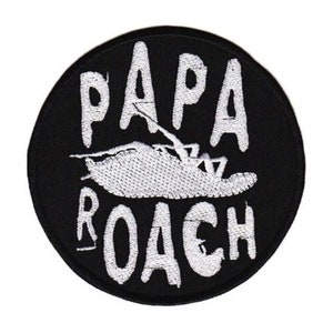 May include: A round, black patch with white embroidered text and a detailed insect illustration. The text reads "PAPA ROACH" in a bold, stylized font, with the insect design centered between the words.