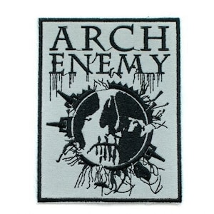 Könnte beinhalten: Schwarz-weiß gestickter Patch mit dem Text "Arch Enemy" und einem schädelartigen Bild in der Mitte.