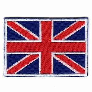 Może przedstawiać: Haftowana naszywka przedstawiająca Union Jack, flagę Zjednoczonego Królestwa. Naszywka ma niebieskie tło z czerwonymi i białymi krzyżami. Prostokątna naszywka ma białą obwódkę.
