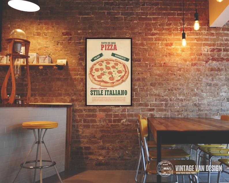 May include: A framed vintage-style pizza poster with the words "FATTO IN CASA PIZZA" and "STILE ITALIANO". The poster features a pizza with salami and margherita toppings. The background is a brick wall in a restaurant setting.