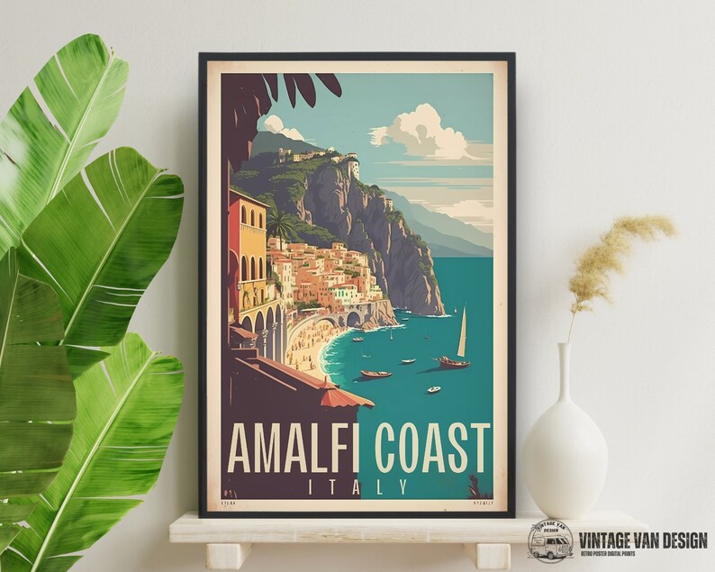 May include: A vintage travel poster featuring a colorful illustration of the Amalfi Coast in Italy. The poster has a blue background with a view of a town built into the side of a cliff overlooking a turquoise sea. The text "Amalfi Coast Italy" is printed in white at the bottom of the poster.