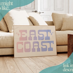 Puede incluir: Una impresi&oacute;n en lienzo beige con el texto "EAST COAST" en una fuente degradada azul y rosa. La impresi&oacute;n se muestra en un sof&aacute; en un sal&oacute;n.