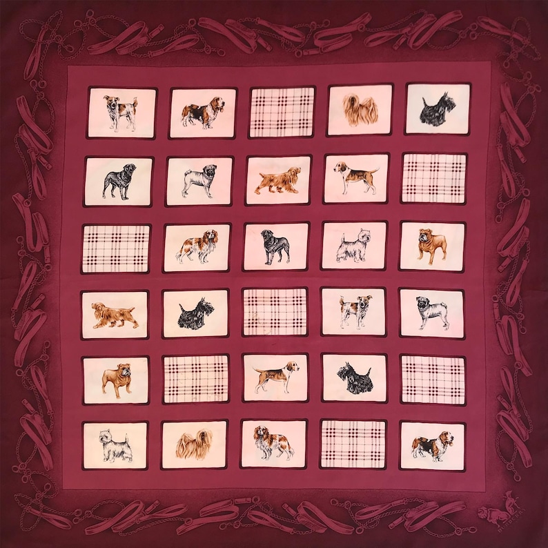 May include: A burgundy square scarf featuring a repeating pattern of dog illustrations within white frames. The scarf has a border of dog leashes and a plaid pattern. The dogs are of various breeds and colors.