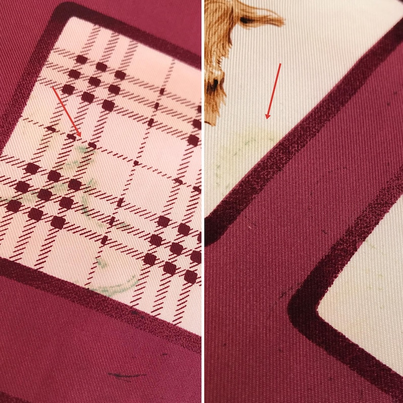 May include: Close-up of a silk scarf with a plaid pattern in burgundy, cream, and black. The scarf has a border of solid burgundy. A small illustration of a brown animal is visible on the cream-colored section.