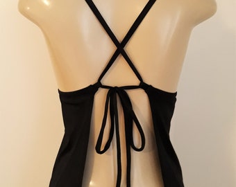 May include: Black sleeveless top with a criss-cross back and a tie closure at the back.