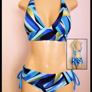 May include: A blue and green geometric patterned bikini with a halter top and a tie-side bottom.