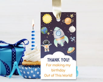 May include: A blue and white thank you tag with a rocket ship, astronaut, planets, and stars. The text reads "Thank You! For making my birthday Out of This World!"