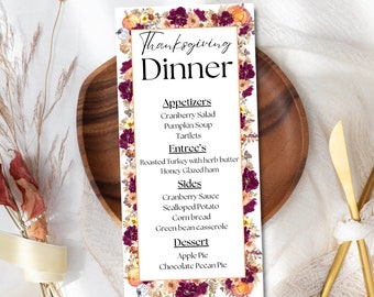 Può includere: Un menu di cena del Ringraziamento stampabile con un bordo floreale e zucche a tema autunnale. Il menu include antipasti, un piatto principale, contorni e dessert.