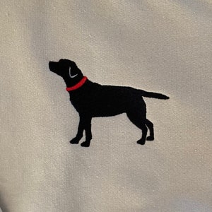 May include: A light gray sweatshirt with a black embroidered silhouette of a Labrador Retriever wearing a red collar.