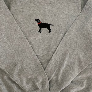 May include: A gray sweatshirt with a black embroidered Labrador Retriever wearing a red collar.