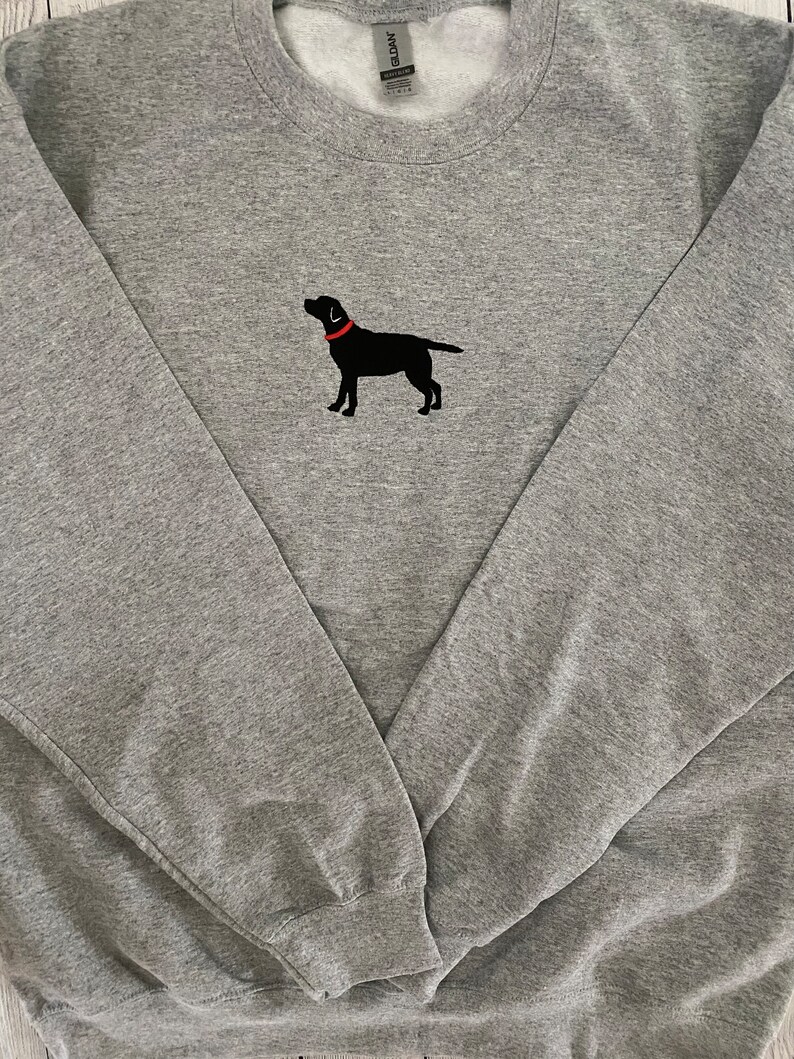May include: A gray sweatshirt with a black embroidered Labrador Retriever wearing a red collar.