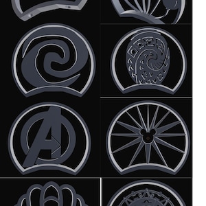 Könnte beinhalten: Eine Sammlung von acht grauen, kreisförmigen, ohrförmigen dekorativen Aufsätzen mit verschiedenen ausgeschnittenen Designs, darunter eine Spirale, ein Totenkopf, eine Muschel, ein Rad, ein Buchstabe A und ein Ballonbündel auf schwarzem Grund.