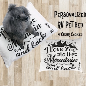May include: Personalized RV pet bed with a white background and black text that says "I love you to the mountain and back". The bed is decorated with a mountain range and hearts. The text is personalized with the name "Daisy".