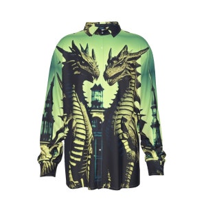 Könnte beinhalten: Langärmliges Button-Down-Hemd mit einem auffälligen Drachendesign. Das Hemd zeigt zwei Drachen, die sich vor einem grünen und schwarzen Farbverlauf gegenüberstehen. Das Design beinhaltet architektonische Elemente und schafft ein Fantasy-Thema.