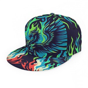May include: A navy blue flat-brimmed baseball cap with a striking phoenix design. The cap displays a phoenix with blue and green flames on a dark backdrop. The brim features a colourful flame pattern.