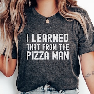 May include: A dark gray t-shirt with the text "I LEARNED THAT FROM THE PIZZA MAN" printed in white.