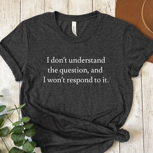 May include: A dark gray t-shirt with the text "I don't understand the question, and I won't respond to it." printed in white.