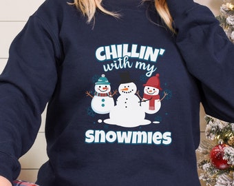 May include: Navy blue sweatshirt with a Christmas-themed graphic that says "Chillin' with my snowmies". The graphic features three snowmen with red, green, and blue hats.