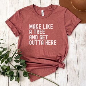 May include: A maroon t-shirt with the text "Make like a tree and get outta here" printed in white.