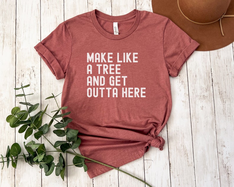 May include: A maroon t-shirt with the text "Make like a tree and get outta here" printed in white.