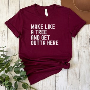 May include: Burgundy t-shirt with white text that reads "Make like a tree and get outta here."