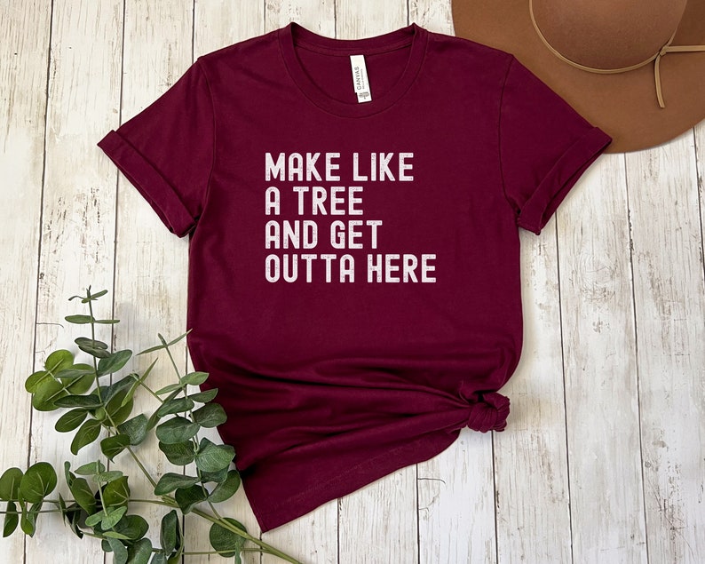 May include: Burgundy t-shirt with white text that reads "Make like a tree and get outta here."