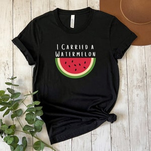 Może przedstawiać: Czarny T-shirt z napisem "I carried a watermelon" i grafiką plasterka arbuza.