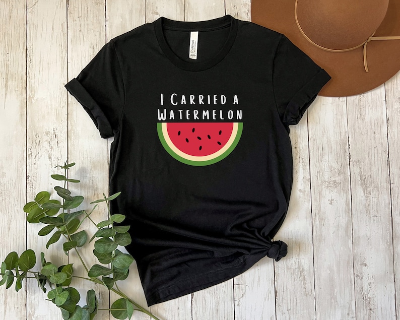 Może przedstawiać: Czarny T-shirt z napisem "I carried a watermelon" i grafiką plasterka arbuza.