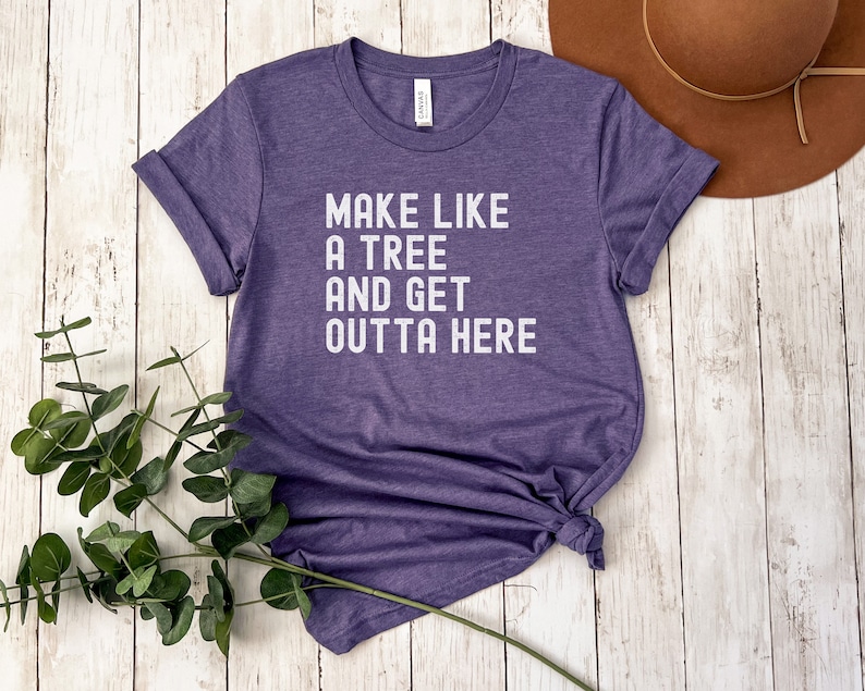 May include: Purple t-shirt with the text "Make like a tree and get outta here" printed in white.