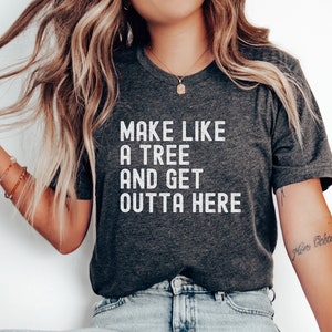 May include: A dark gray t-shirt with the text "Make like a tree and get outta here" printed in white.