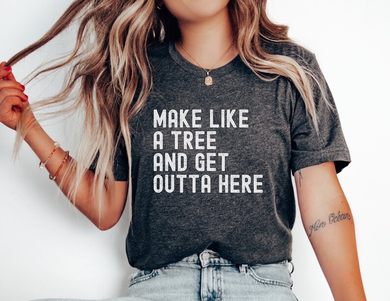 May include: A dark gray t-shirt with the text "Make like a tree and get outta here" printed in white.