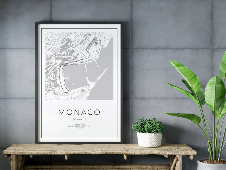 K&ouml;nnte beinhalten: Ein gerahmter Schwarz-Wei&szlig;-Druck der Rennstreckenkarte des Monaco Grand Prix. Der Druck enth&auml;lt das Wort "MONACO" und Details zur Streckenl&auml;nge und Anzahl der Kurven. Der Druck wird auf einem rustikalen Holztisch pr&auml;sentiert. Die Streckenl&auml;nge betr&auml;gt 3,337 km.