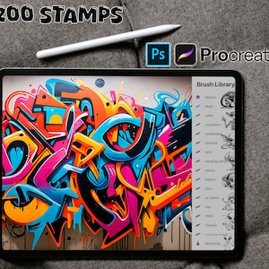 Könnte beinhalten: Ein digitales Tablet zeigt ein farbenfrohes abstraktes Graffiti-Design auf dem Bildschirm. Das Tablet liegt auf einer grauen Oberfläche mit einem weißen Stift und einem Logo für Adobe Photoshop und Procreate. Der Bildschirm des Tablets zeigt auch eine Liste von Pinselbibliotheken, darunter "Aktuell", "tot", "Kabine", "Berge", "Landschaft", "Flugzeug", "Tarot", "Hängende Pflanzen", "Kaktus", "Bigfoot", "Alice", "Luftpflanzen", "Geo", "BAUM", "Blumen" und "Skizzieren".