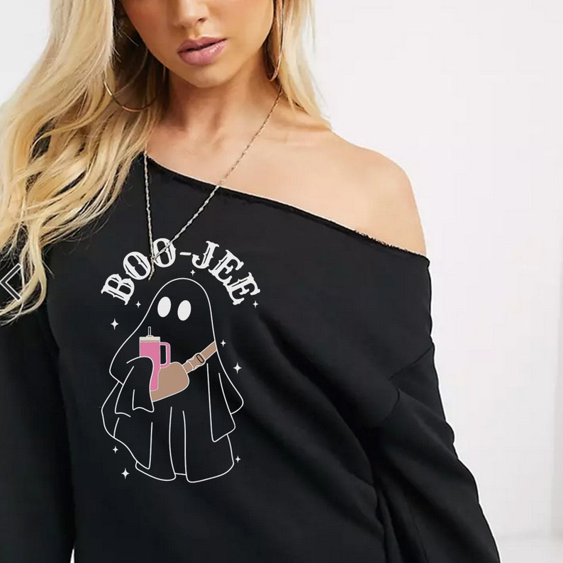 May include: Black off-the-shoulder sweatshirt with a graphic of a ghost holding a pink drink and the text "BOO-JEE".