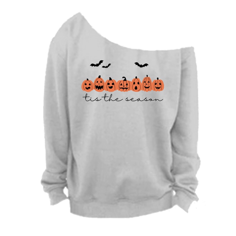 May include: Gray off-the-shoulder sweatshirt with a line of orange pumpkins with black faces and the text "tis the season" printed on the front.