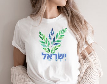 Könnte beinhalten: Weißes T-Shirt mit einem blauen und grünen Aquarelldesign aus Blättern und dem hebräischen Text "!שלום" (bedeutet "Frieden")