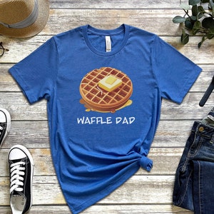 K&ouml;nnte beinhalten: Ein blaues T-Shirt mit einem Waffel-Motiv und dem Aufdruck "Waffle Dad".