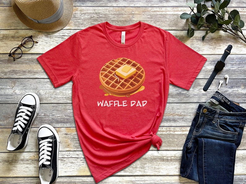 K&ouml;nnte beinhalten: Rotes T-Shirt mit kurzen &Auml;rmeln, einem Waffel- und Butter-Motiv und dem Text "Waffle Dad".