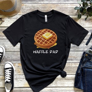 K&ouml;nnte beinhalten: Schwarzes T-Shirt mit einem Waffel-Motiv und dem Aufdruck "Waffle Dad".