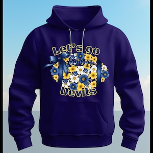May include: A navy blue hoodie with a front pocket and drawstring hood. The front features a football design made of blue, yellow, and white flowers, with the text "Let's go Devils" in yellow and white.