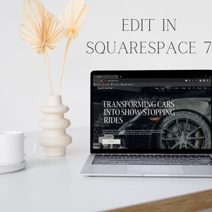 May include: A laptop computer displaying a website with the text "Transforming Cars into Show Stopping Rides" on a white desk with a white mug and a vase with dried palm leaves.