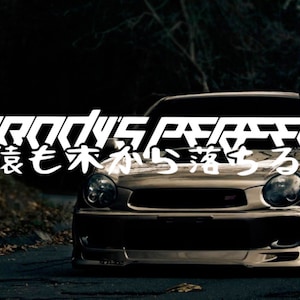 May include: A black Subaru Impreza with a white vinyl decal that reads "NORANDY'S PERFECT" and "狼も木から落ちる".